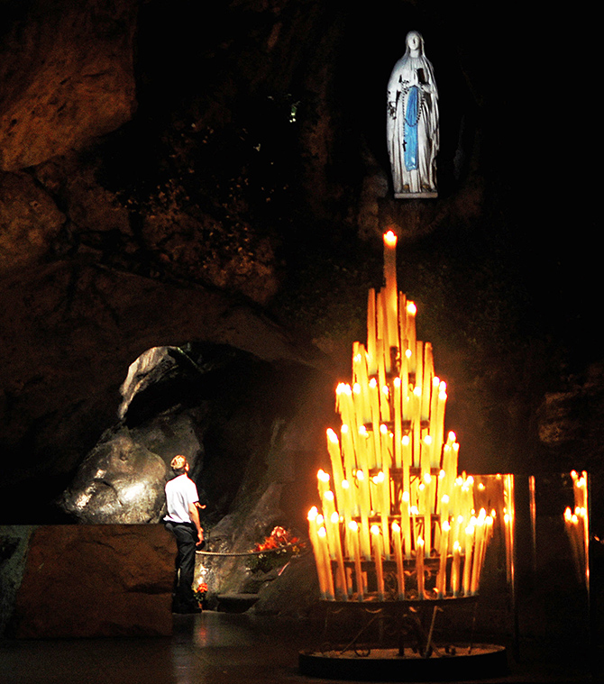 Foto der Grotte von Lourdes bei Nacht mit einem betenden Soldaten, Hochgeladen von Marschnell, Wikimedia Commons